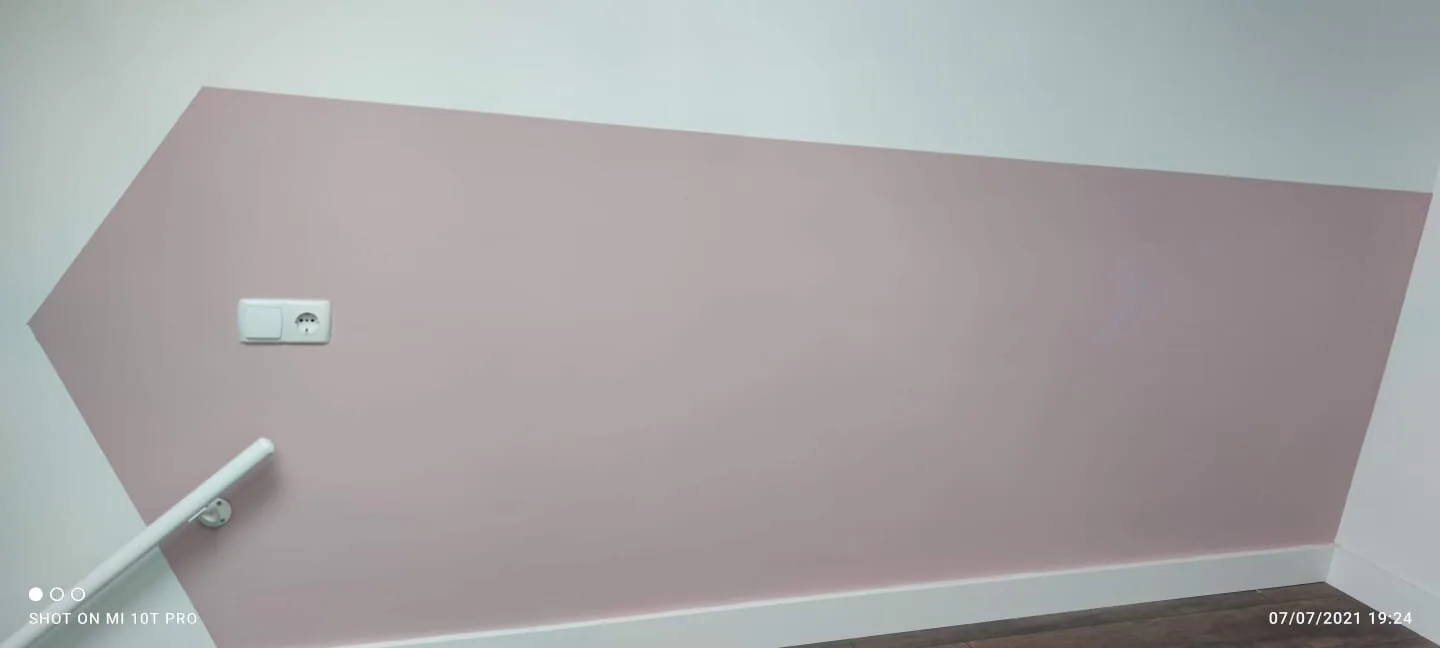 Strak geverfde muur met geometrisch patroon en stopcontact.